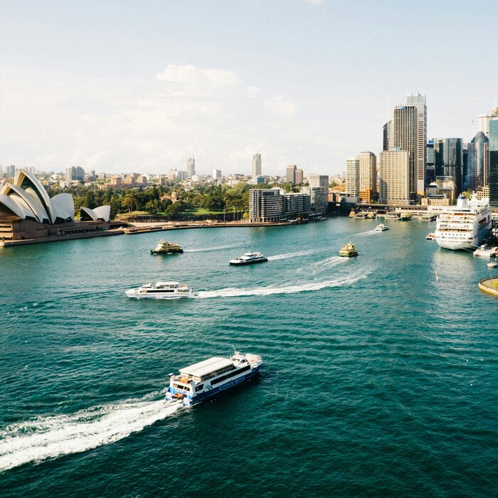 Symbolbild Australien, Ozeanien: See mit Schiffen und Große Stadt