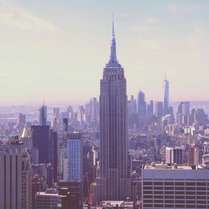 Symboldbild Amerika: Sonnenaufgang in heller Stadt mit großen Gebäuden.